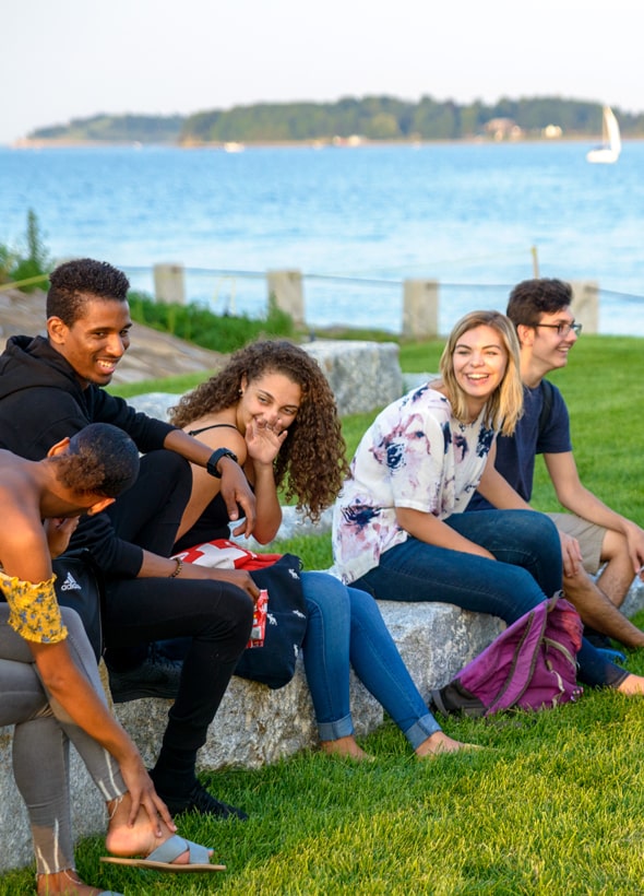 Students Sitting on Stone Blocks on Campus Center Lawn