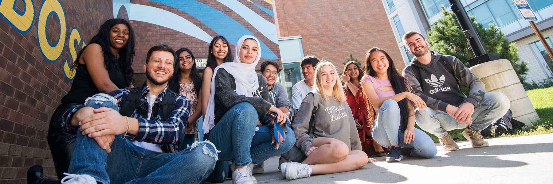 Large group of students pose in front of the Service and Supply building.