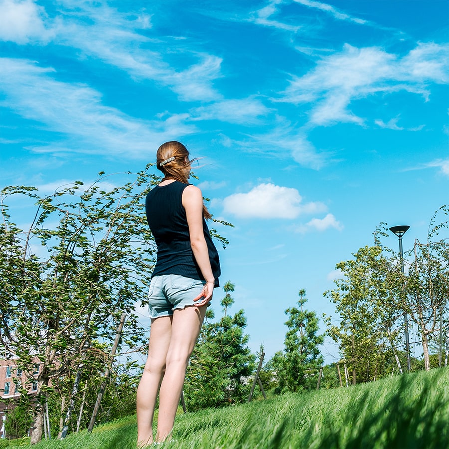 student in field of grass in quad