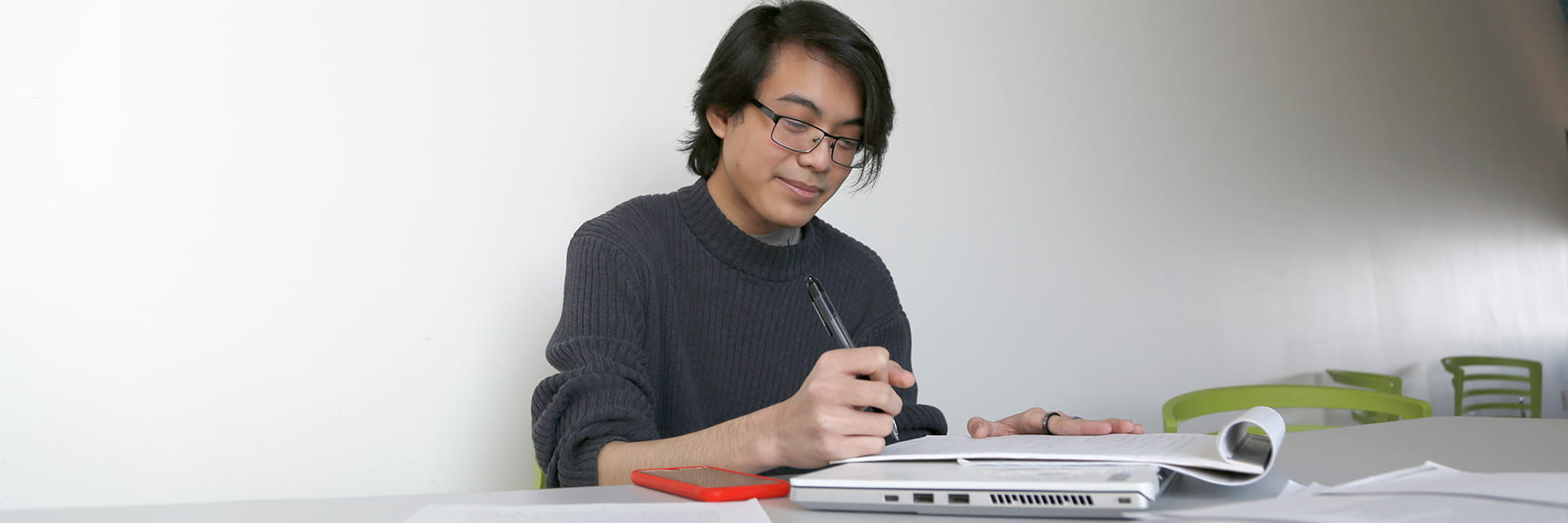 Student holding pen & writing photo Lisa L.