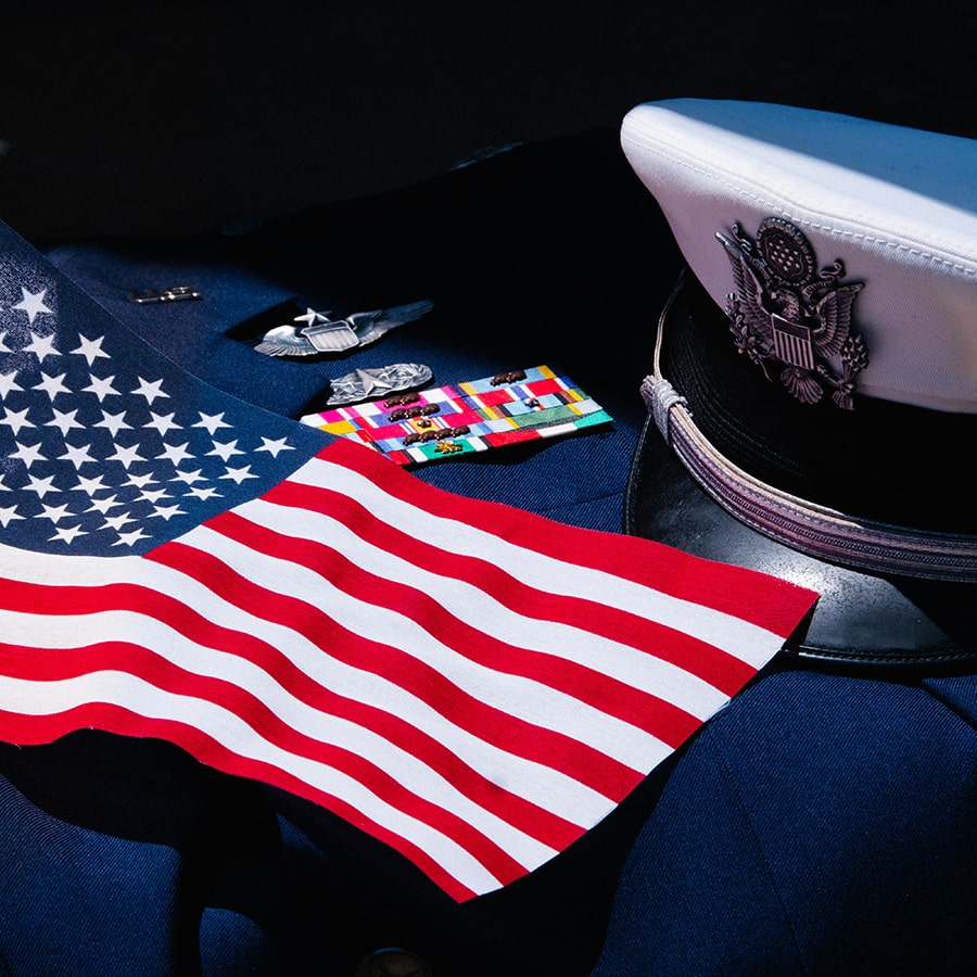 American flag laying on top of a uniform - Photo by Wesley Tingey on Unsplash