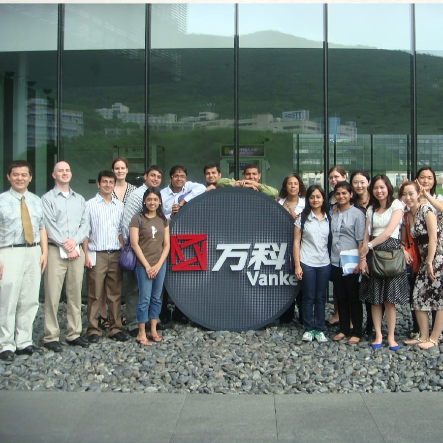Students and hosts pose in front of Vanke company in China,